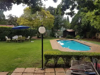 a pool in a yard with a sign next to it at Roosboompies Guest Suite in Centurion