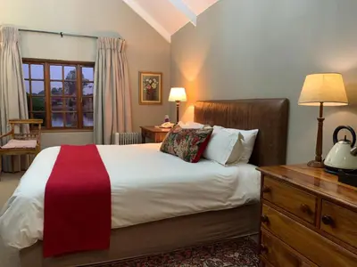 a bedroom with a large bed and a dresser at Critchley Hackle - Tower rooms in Dullstroom