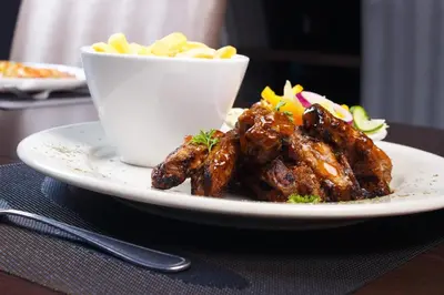 a plate of food with meat and a bowl of fries at Ndalo Lodge Oshoek in Oshoek