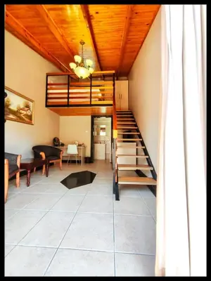 a room with a staircase and a living room at Jabliano Guest House in Secunda