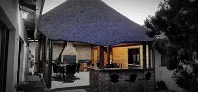 a house with a large roof on a patio at Jabliano Guest House in Secunda