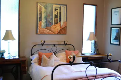 a bedroom with a bed with white sheets and orange pillows at The Gables Guest House in Belfast
