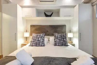 a bedroom with a large white bed with two pillows at The Regency Apartments in Pretoria
