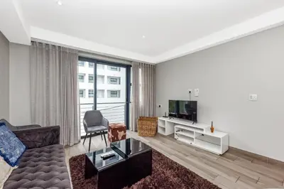 a living room with a couch and a tv at The Regency Apartments in Pretoria