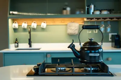 a tea kettle on a stove in a kitchen at AfriCamps Magoebaskloof in Magoebaskloof