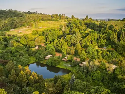 an aerial view of a house and a lake at AfriCamps Magoebaskloof in Magoebaskloof