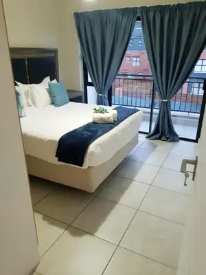 a bedroom with a bed and a large window at Apartment 432 @ The Blyde Riverwalk Pretoria in Pretoria