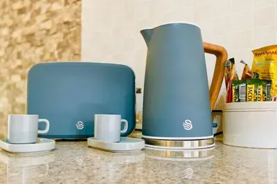 a blue coffee pot and two cups on a counter at Phoenix Rising Apartment in Midrand