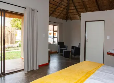 a bedroom with a bed and a living room at Bongan Safari Lodge in Mbabat