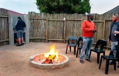 a group of people standing around a fire pit at Bongan Safari Lodge in Mbabat