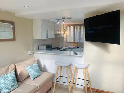 a living room with a couch and a kitchen at The Loft@Santorini in Pretoria