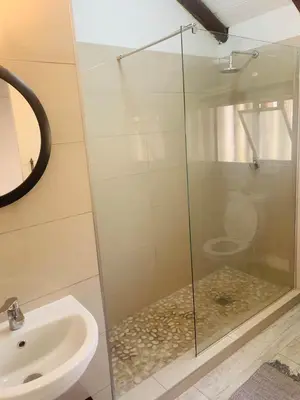 a glass shower in a bathroom with a toilet at The Loft@Santorini in Pretoria