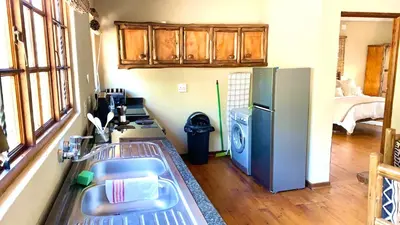 a kitchen with a sink and a refrigerator at Hope Haven Cottage in Nelspruit