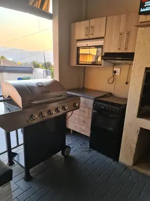 a kitchen with a grill on a stove top oven at SummerField Guest House in eNyamazaneni