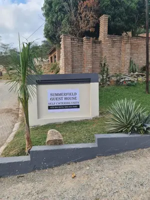 a sign for a guest house in a yard at SummerField Guest House in eNyamazaneni