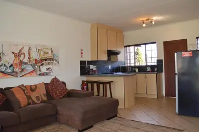 a living room with a couch and a kitchen at Dullstroom Artist Cottages in Dullstroom