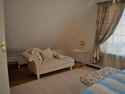 a living room with a couch and a table at Dullstroom Artist Cottages in Dullstroom