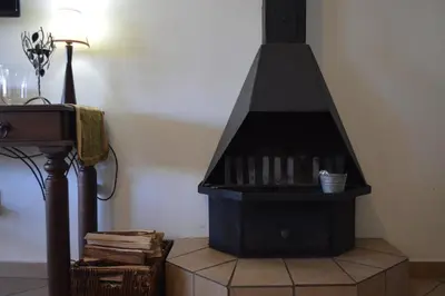 a black stove in a living room with books at Dullstroom Artist Cottages in Dullstroom