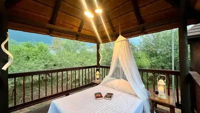 a bedroom with a bed on a balcony with trees at Kruger Kumba - Mugwenzi in Marloth Park