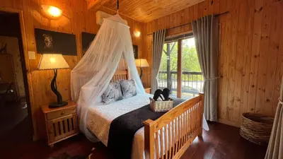 a bedroom with a bed with a mosquito net at Kruger Kumba - Mugwenzi in Marloth Park
