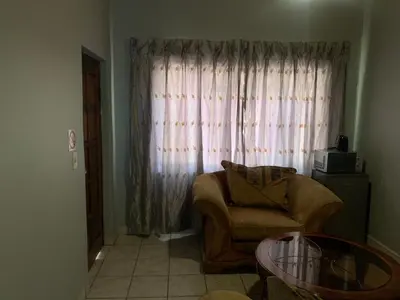 a living room with a chair and a window at Waterfall View Lodge in Midrand