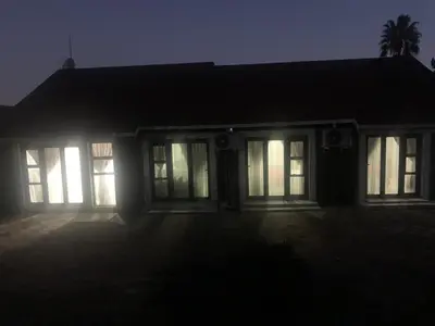 a house at night with the lights on at Waterfall View Lodge in Midrand