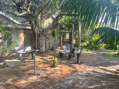 a patio with a bench and a picnic table at Rosscos Lodge in Phalaborwa