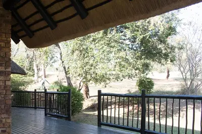 a porch with a fence and trees in the background at Kruger Park Lodge Unit 245 in Hazyview