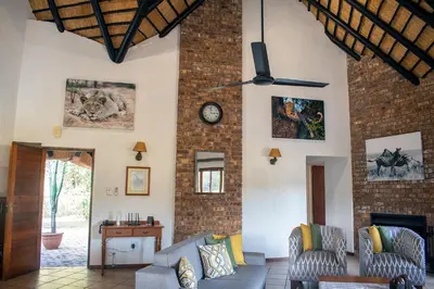 a living room with a couch and a clock on the wall at Kruger Park Lodge Unit 245 in Hazyview
