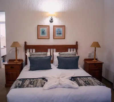 a bedroom with a bed with a bow on it at Kruger Park Lodge Unit 245 in Hazyview