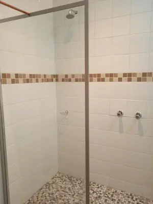 a shower with a glass door in a bathroom at Ratel Street Guesthouse in Pretoria