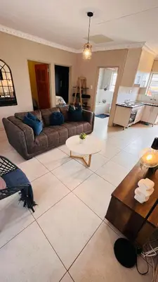 a living room with a couch and a table at Zinathi Lodge in Polokwane