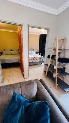 a living room with a couch and a bed at Zinathi Lodge in Polokwane