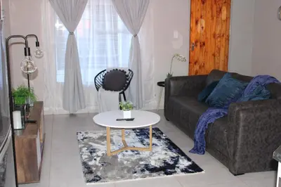 a living room with a couch and a table at Zinathi Lodge in Polokwane