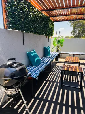 a patio with a grill and benches and a table at Zinathi Lodge in Polokwane