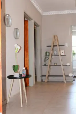 a living room with a table and a ladder at Zinathi Lodge in Polokwane