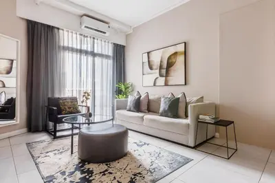 a living room with a couch and a table at The Menlyn Main Residents Trilogy in Pretoria