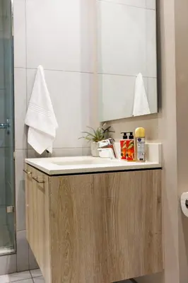 a bathroom with a sink and a mirror at The Menlyn Main Residents Trilogy in Pretoria