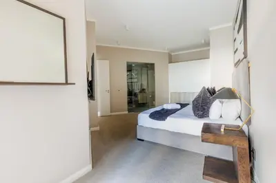 a bedroom with a bed and a framed picture on the wall at The Menlyn Main Residents Trilogy in Pretoria