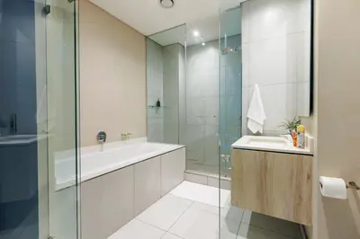 a bathroom with a tub and a sink and a shower at The Menlyn Main Residents Trilogy in Pretoria