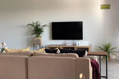 a living room with a couch and a flat screen tv at Spectacular 2 bedroom Penthouse Apartment in Midrand