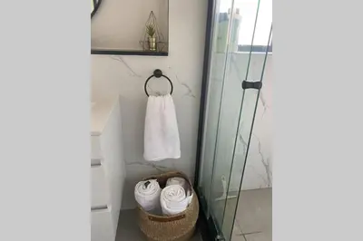 a bathroom with a shower and a basket of towels at Spectacular 2 bedroom Penthouse Apartment in Midrand