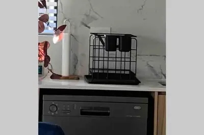 a kitchen counter with a dishwasher with a bird cage on it at Spectacular 2 bedroom Penthouse Apartment in Midrand