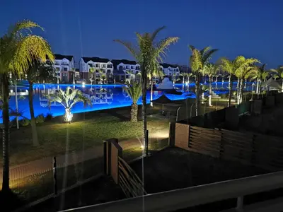 a view of a resort at night with palm trees at The Blyde Beach View in Pretoria