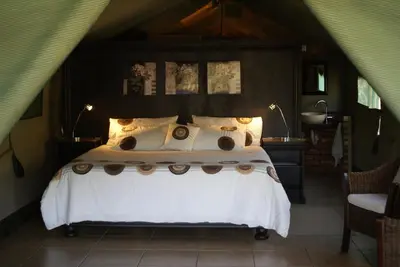 a bedroom with a bed with white sheets and pillows at Beka Idube Bushveld Retreat in Cullinan