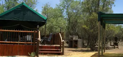 a playground with a green canopy and a wooden fence at Beka Idube Bushveld Retreat in Cullinan