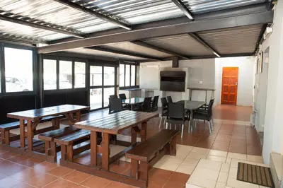 a dining room with wooden tables and chairs at M n M Guesthouse Polokwane Central in Polokwane