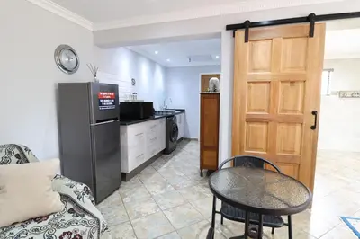 a kitchen with a refrigerator and a table in a room at 7 At Brainline in Pretoria