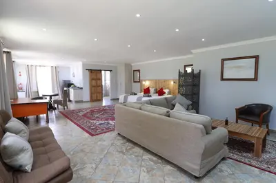 a living room with couches and a living room with a table at 7 At Brainline in Pretoria