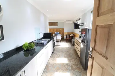 a kitchen with a black counter top and a refrigerator at 7 At Brainline in Pretoria